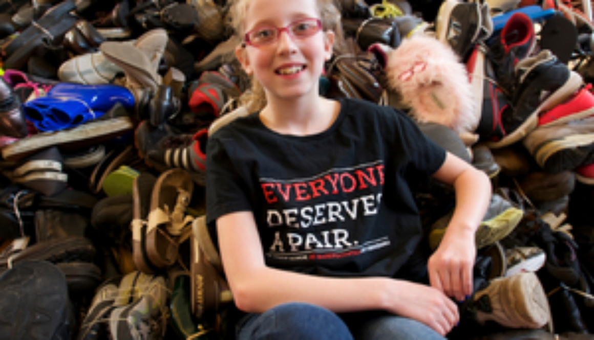 Girl on large pile of shoes