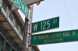 Green street sign with white writing W 125 St and Dr. Martin Luther King Boulevard