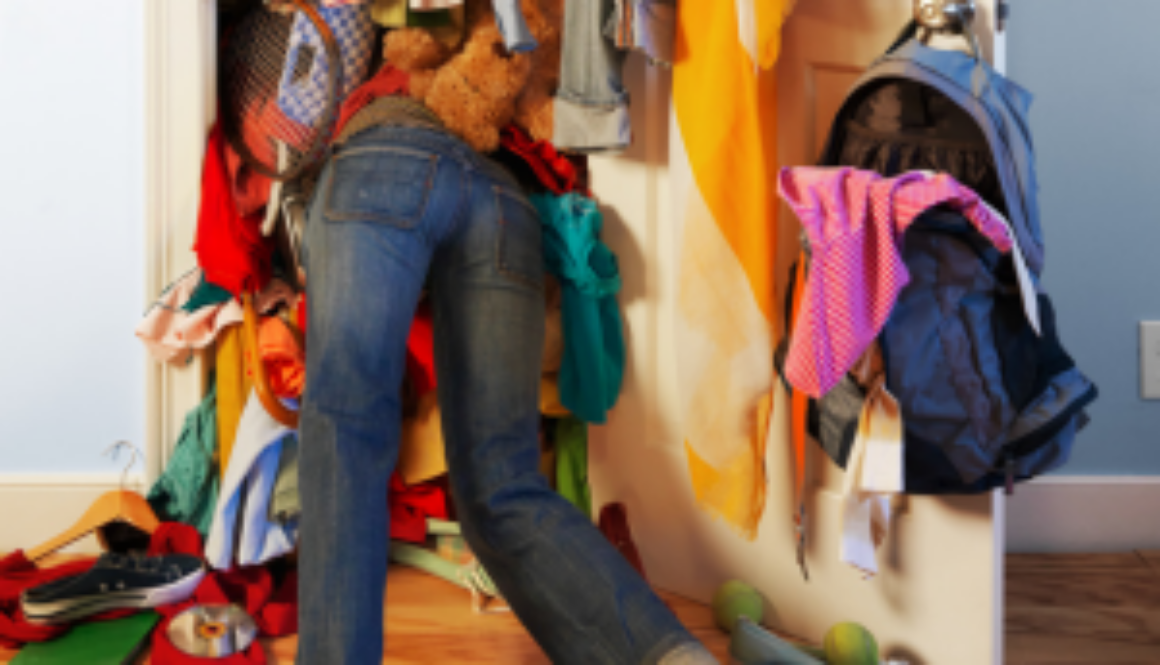 lady in closet overflowing with clothes