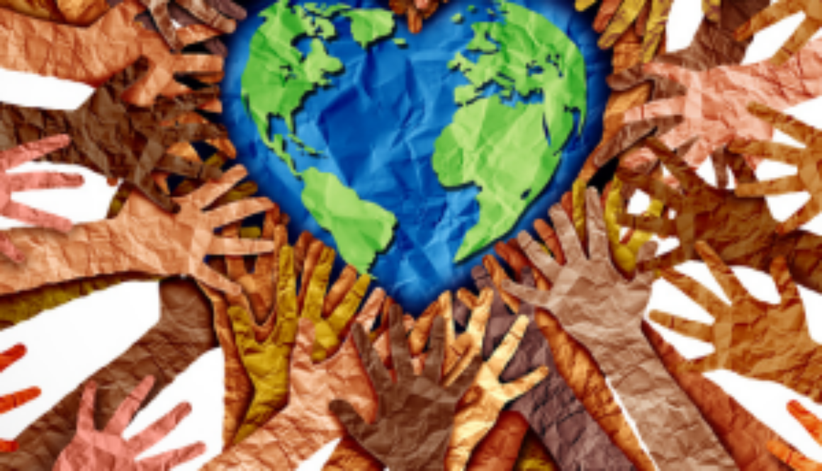 Heart-shaped paper Earth surrounded by paper hands made with many different skin tone colors.