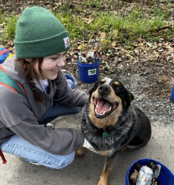 Girl with dog with bucket of litter they picked up