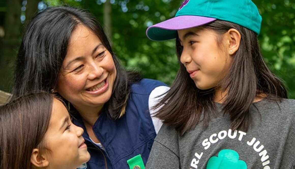 Lady and two girls, one with a Junior Girl Scouts t-shirt and ball cap