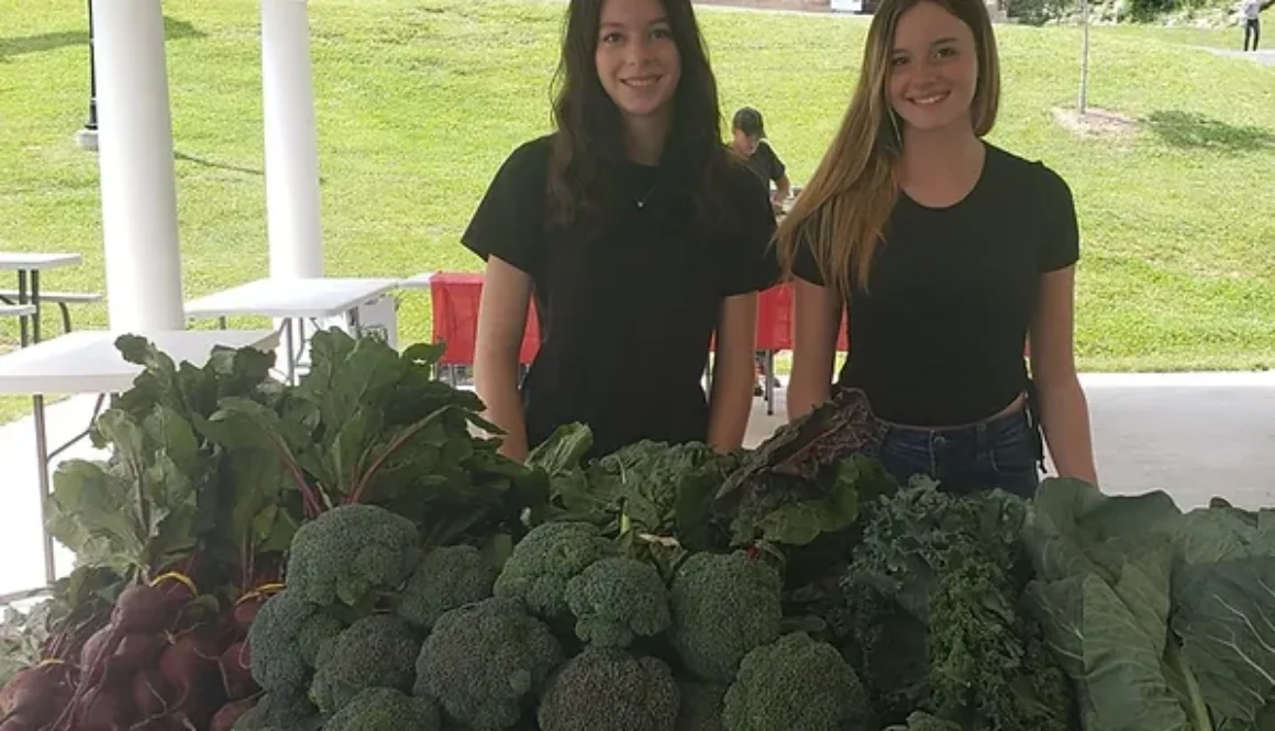 Young ladies with fresh produce at the Highland Center Pavilion Farmers Market
