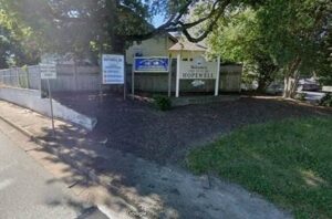 Photo of a street with an entrance sign and mulched area
