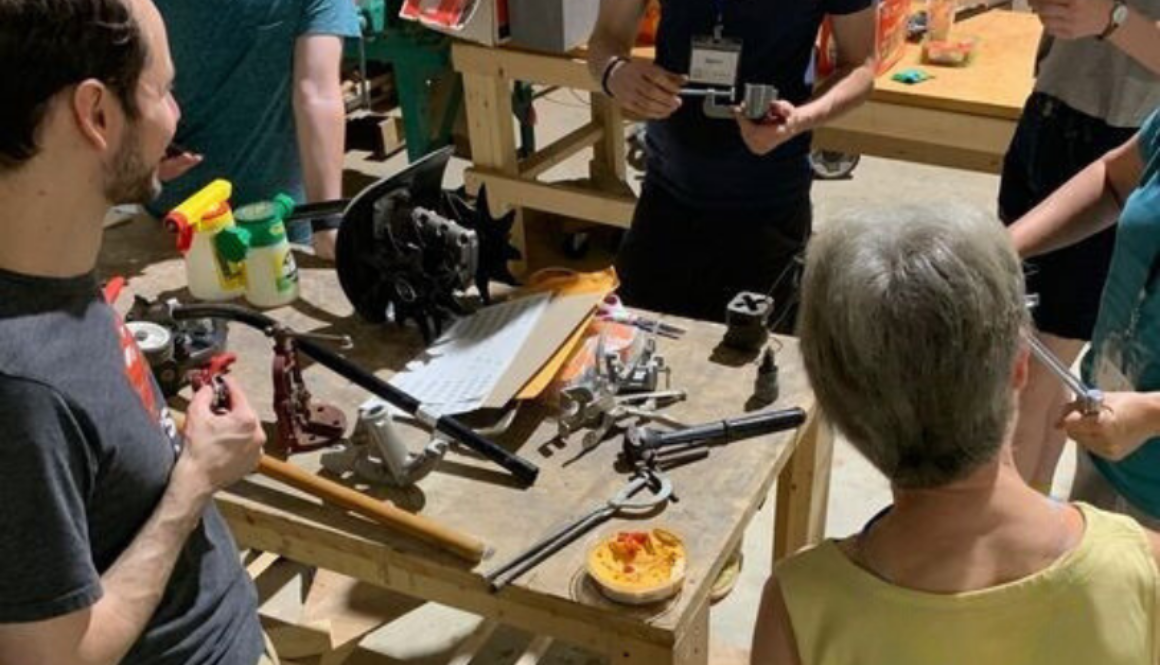 Photo of people around a work table with various hand tools