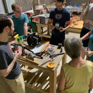Photo of people around a work table with various hand tools