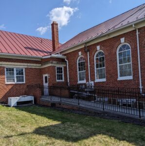 Area near brick church building that will hold benches and cigarette butt receptacles
