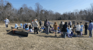 Photograph of people gathering out in a field