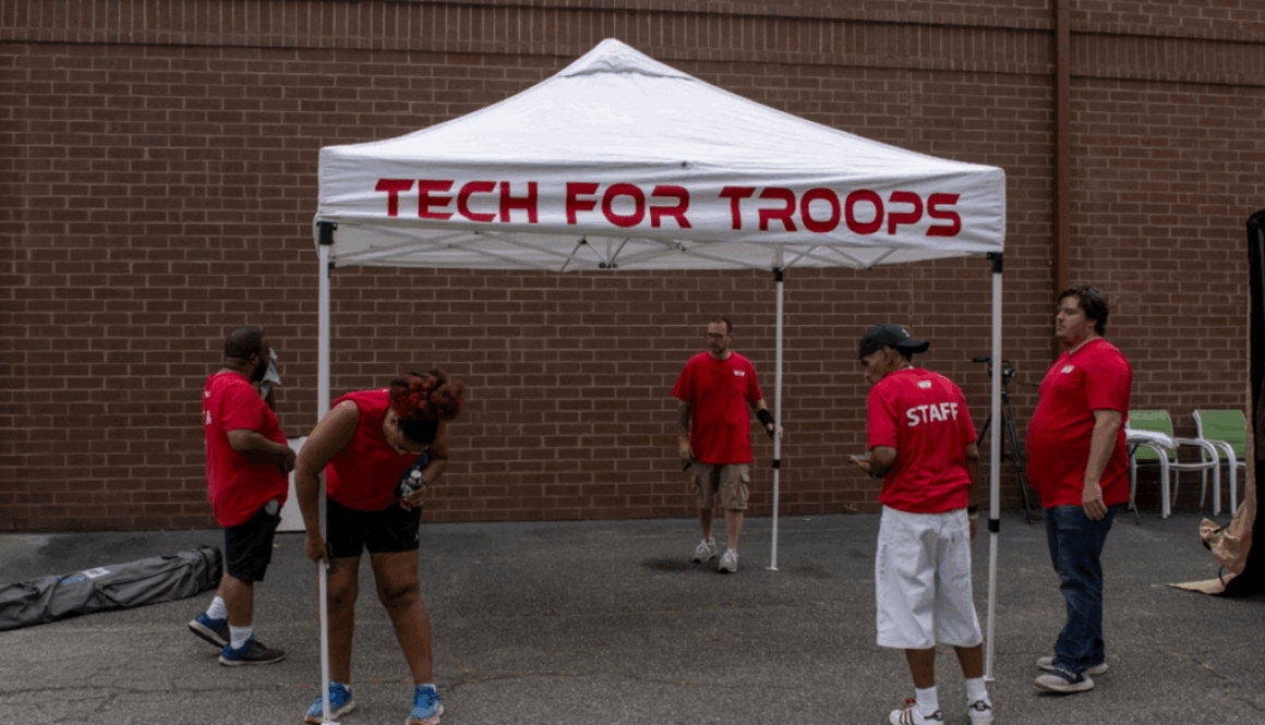 Photo of Tech For Troops staff setting up a tent to collect donations of electronic waste.