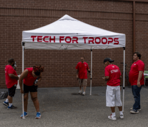 Photo of Tech For Troops staff setting up a tent to collect donations of electronic waste.